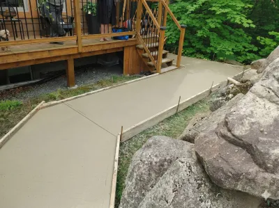Allée de jardin en béton avec aménagement rocheux